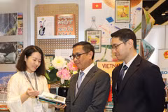 Des visiteurs étrangers découvrent des ouvrages sur la culture, le pays, le peuple et le tourisme du Vietnam lors de l'événement. Photo : VNA. 