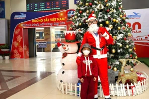 Dès le quai, l’ambiance de Noël se fait sentir : les employés du secteur ferroviaire se déguisent en Père Noël et offrent des cadeaux aux enfants voyageant en train. Photo : tienphong.vn