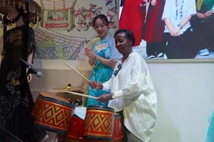 Louise Mushikiwabo expérimente les instruments de musique traditionnels du Vietnam. Photo : baoquocte.vn