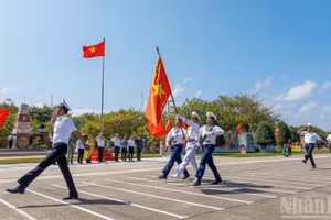 La revue des troupes se déroule sous le drapeau national et à proximité de la borne marquant la souveraineté sur l’archipel de Truong Sa. Photo : NDEL
