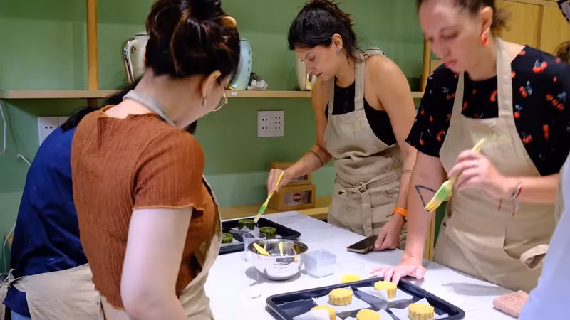 Grâce aux conseils dévoués d’experts culinaires vietnamiens, des amis étrangers apprennent à combiner des ingrédients pour créer deux types de gâteaux de lune que sont le « banh nuong » (gâteau farci cuit au four) et « le banh deo » (gâteau de pâte de riz gluant farci). Photo: VTV.