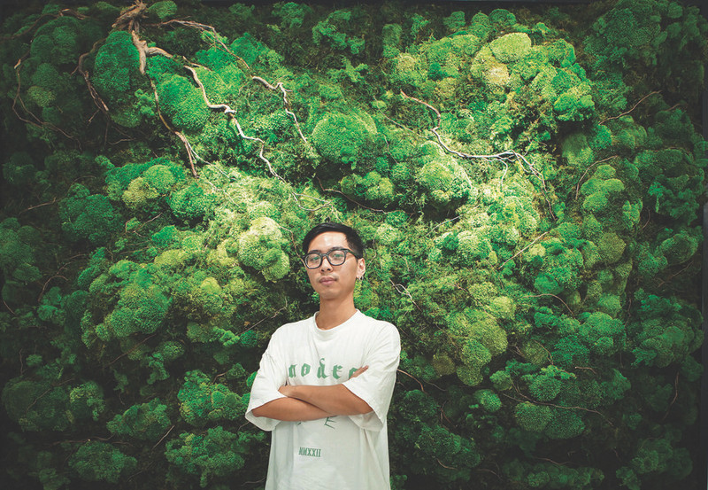 Hoàng Tuân Anh devant son oeuvre "Vue aérienne de la forêt". 
