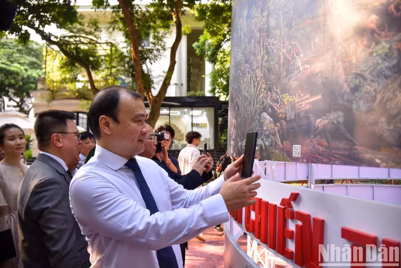 Lê Hai Binh, membre suppléant du Comité central du PCV, rédacteur en chef de « Tap chi Công San » (Revue Communiste), expérimente une interaction sur la peinture panoramique circulaire « Campagne de Diên Biên Phu ». Photo: NDEL.