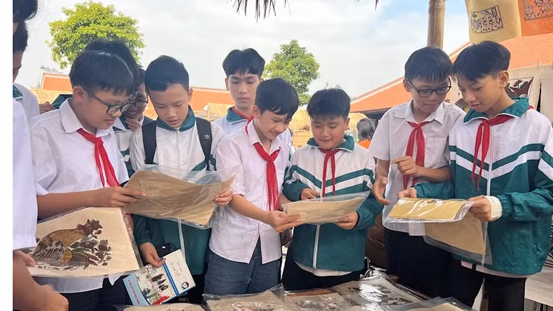 Les élèves sont ravis de découvrir le métier de fabrication des estampes populaires de Dông Hô. Photo : NDEL.