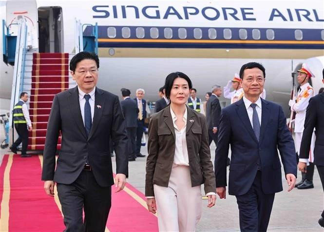 Le ministre des Sciences et des Technologies, Nguyen Manh Hung (droite) accueille le Premier ministre Lawrence Wong à l'aéroport international de Noi Bai. Photo : VNA 