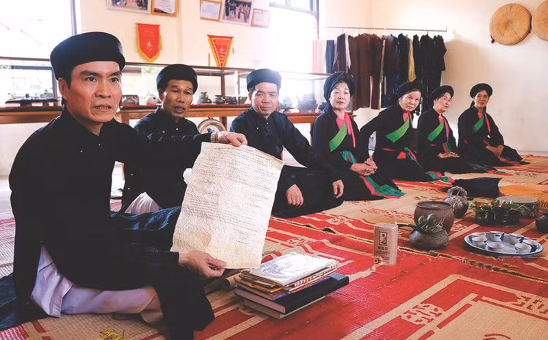 Duong Duc Thang (1er à gauche) présente un document sur les airs authentiques de "quan ho". Photo : BBN/CVN.