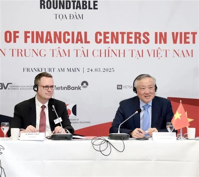 Le vice-Premier ministre permanent Nguyên Hoa Binh (à droite) préside la table ronde sur le développement des centers financiers au Vietnam. Photo : VNA. 