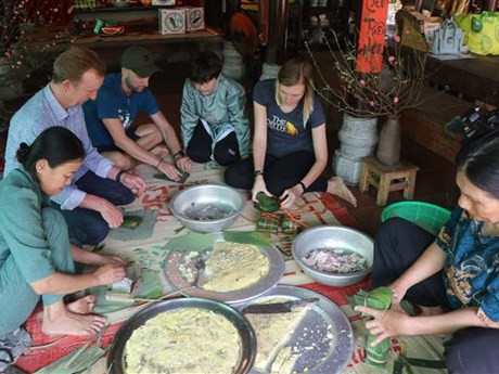 Des touristes étrangers honorent cet art qu’est la calligraphie de même que la tradition de demander aux lettrés des idéogrammes. Photo : VNA.