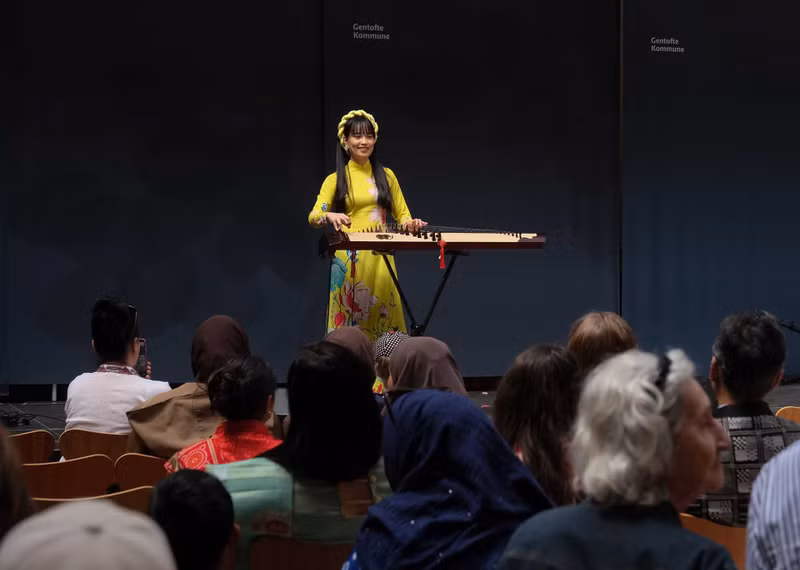 La performance de l’artiste de cithare Dieu Ly, une Vietnamienne résidant à Copenhague, a reçu les acclamations enthousiastes du public. Photo: baoquocte.vn. La performance de l’artiste de cithare Dieu Ly, une Vietnamienne résidant à Copenhague, a reçu les acclamations enthousiastes du public. Photo: baoquocte.vn.