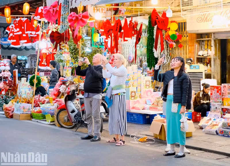 Pour les étrangers, la fête de Noël est une de leurs grandes fêtes de l’année. À l’approche de cette fête, de nombreux étrangers viennent visiter la rue de Hang Ma pour acheter des produits de décoration. Photo : Trung Hieu/NDEL.