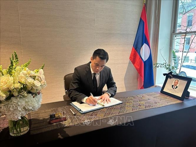 L'ambassadeur Dang Hoang Giang signe le registre de condoléances à la Mission permanente du Laos auprès de l’ONU à New York. Photo : VNA. 