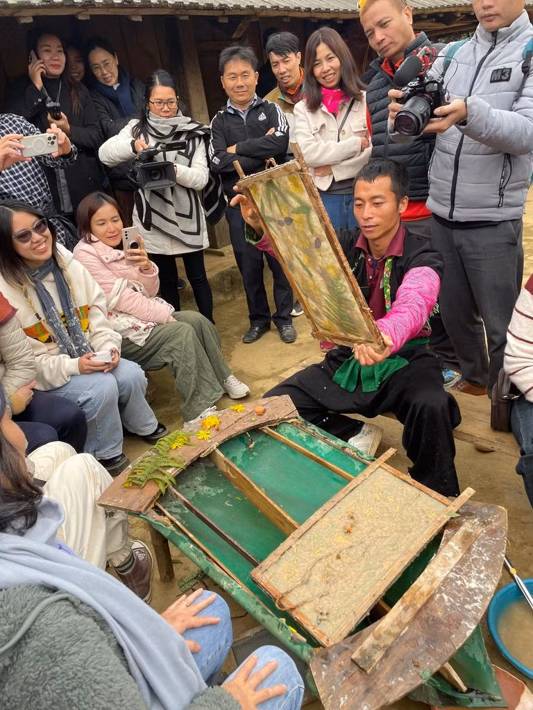Trang A Cua présente aux visiteurs l'art des peintures traditionnelle sur papier. Photo : CVN