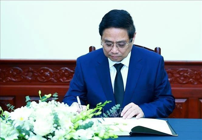 Le Premier ministre Pham Minh Chinh écrit dans le registre de condoléances. Photo : VNA. 
