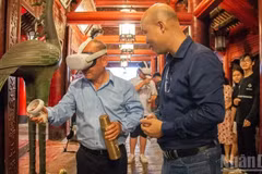 Des visiteurs profitent d’une expérience immersive en réalité virtuelle au Temple de la Littérature de Hanoï. Photo : NDEL.