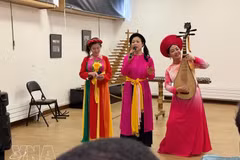 Des artistes interprètent la chanson "Trong Com" (Tambour de riz), traduite en français. Photo : VNA
