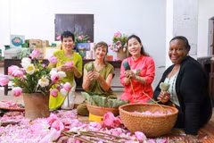 Des visiteurs découvrent l'art de parfumer le thé au lotus de Quảng An. Photo : VNA.