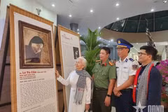 L’ancienne prisonnière politique Lê Tu Câm, émue, contemple son portrait restauré par numérisation et réalisé à partir de feuilles de lotus, exposé au Musée de Côn Dao. Photo : qdnd.vn.