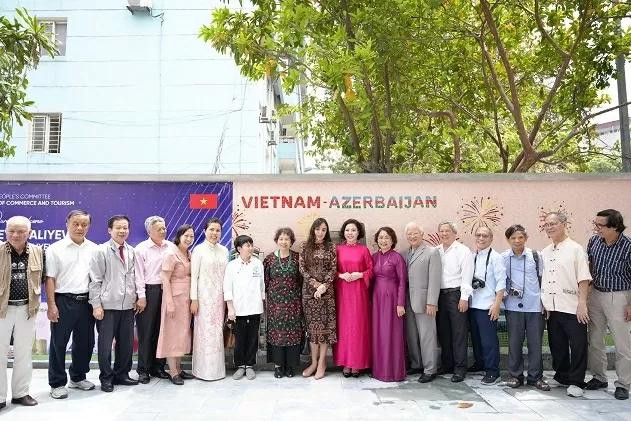 La délégation azerbaïdjanaise prennent des photos souvenirs devant la mosaïque murale en céramique représentant l'amitié entre le Vietnam et l'Azerbaïdjan. Photo : baoquocte.vn