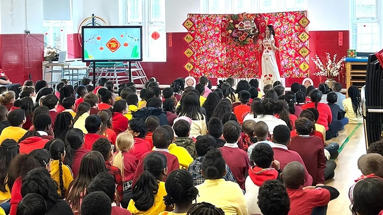 Les élèves de l’Ark Oval Primary Academy ont écouté la créatrice d'origine vietnamienne Anna Hoang présenter sa collection d'áo dài (tenue traditionnelle vietnamienne). Photo: LOANI VN-UK