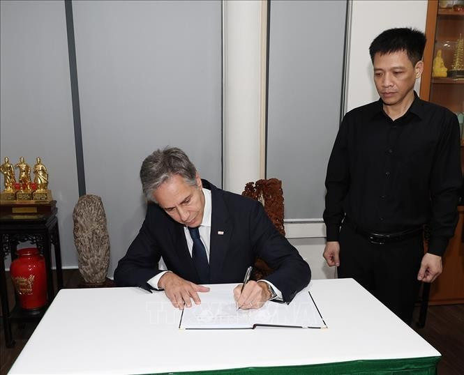 Le secrétaire d'État américain Antony Blinken écrit dans le registre de condoléances. Photo : VNA.