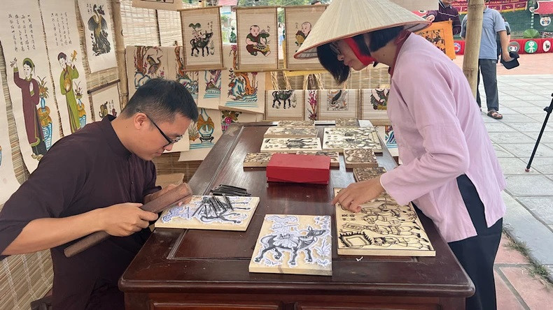 Le jeune artiste Nguyên Huu Dao présente une technique de création d’une estampe de Dông Hô. Photo : NDEL. Le jeune artiste Nguyên Huu Dao présente une technique de création d’une estampe de Dông Hô. Photo : NDEL.