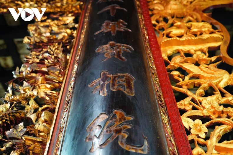 Tous les piliers en bois sont décorés de caractères chinois rouges et dorés. La salle de culte est dominée par la grande statue du Bouddha Amitabha, entourée de cinq petites autres statues de Bouddha. Dans le hall principal se trouve « l’autel des neuf dragons » dépeignant la naissance du prince Sidharta, le futur Bouddha Gautama. Photo : VOV. Tous les piliers en bois sont décorés de caractères chinois rouges et dorés. La salle de culte est dominée par la grande statue du Bouddha Amitabha, entourée de cinq petites autres statues de Bouddha. Dans le hall principal se trouve « l’autel des neuf dragons » dépeignant la naissance du prince Sidharta, le futur Bouddha Gautama. Photo : VOV.