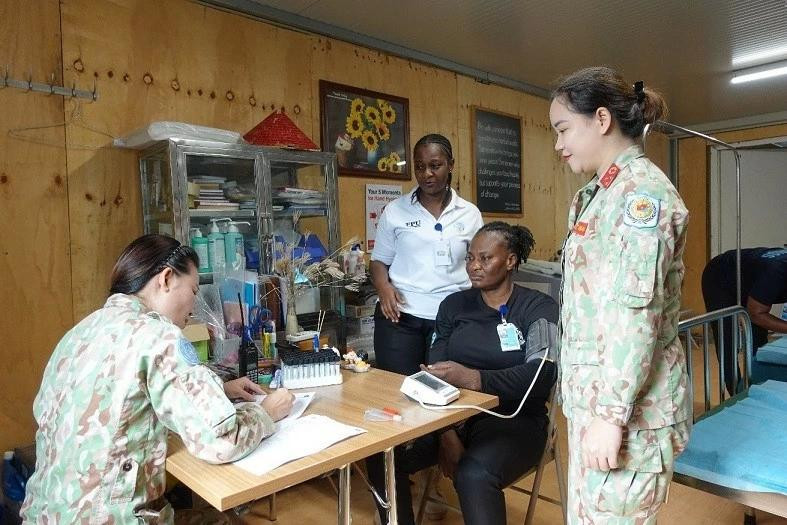 L'infirmière en chef Tran Thuan Trang et la chef du groupe des femmes de l'hôpital Nguyen Thi Thanh Hang donnent des consultations médicales à une policière ghanéenne. Photo: Hôpital de campagne de niveau 2 n° 5