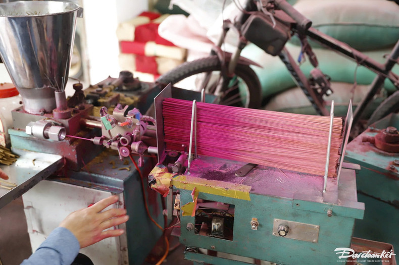 Après avoir séché, les tiges de bambou sont insérées dans une machine pour être taillées, avant d’être plongées dans du colorant rose. Le bâton est ensuite enrobé d’une pâte aromatique, puis est séché à nouveau. Photo: daidoanket.vn. Après avoir séché, les tiges de bambou sont insérées dans une machine pour être taillées, avant d’être plongées dans du colorant rose. Le bâton est ensuite enrobé d’une pâte aromatique, puis est séché à nouveau. Photo: daidoanket.vn.