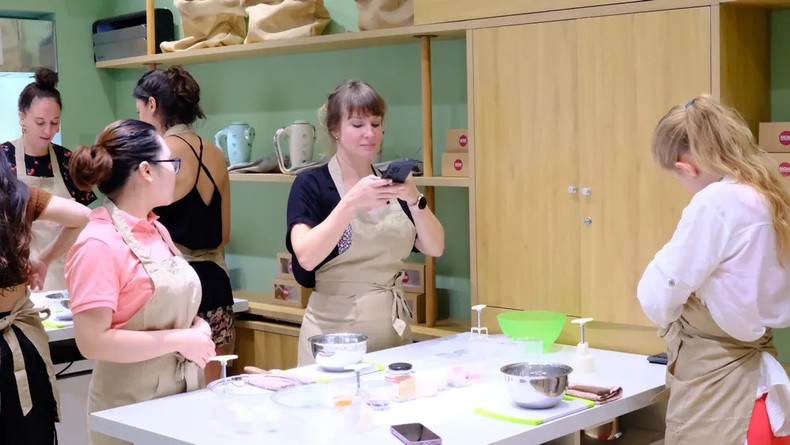 De nombreux touristes étrangers participent à un cours de cuisine à Hô Chi Minh-Ville pour découvrir les secrets de fabrication des gâteaux de lune, un plat emblématique de la fête de la mi-automne. Photo: VTV