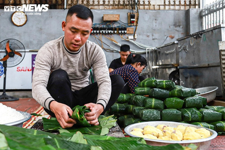 Les principaux ingrédients de cette friandise comprennent du riz gluant, du porc et des haricots verts enveloppés carrés dans des feuilles à larges lames qui donnent au riz une couleur verte après environ 12 heures d'ébullition. Les principaux ingrédients de cette friandise comprennent du riz gluant, du porc et des haricots verts enveloppés carrés dans des feuilles à larges lames qui donnent au riz une couleur verte après environ 12 heures d'ébullition.