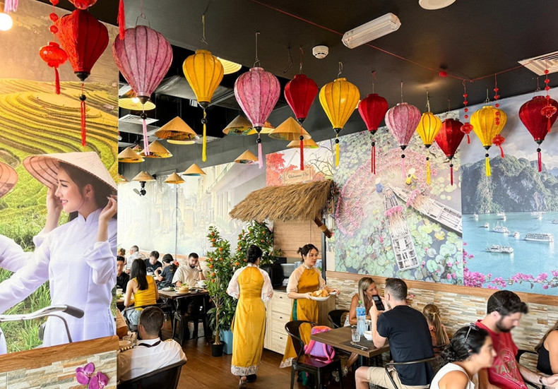 Les serveurs portent l'ao dai. Photo: Vietnamnet Les serveurs portent l'ao dai. Photo: Vietnamnet