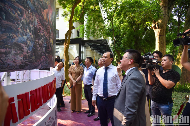 Lê Quôc Minh, membre du Comité central du Parti communiste vietnamien (PCV), rédacteur en chef du journal Nhân Dân, chef adjoint de la Commission centrale de Propagande et d’Éducation du PCV et président de l’Association des journalistes du Vietnam, présente aux délégués les points marquants de l'exposition. Photo: NDEL.