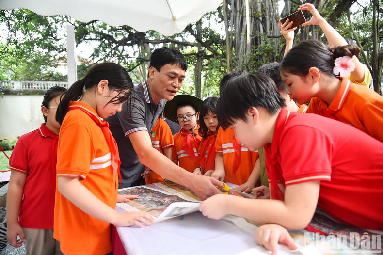 Les élèves découpent et assemblent la version papier de la peinture panoramique. Photo: NDEL.