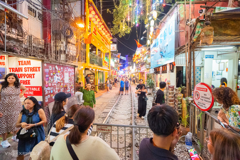 Lorsque la cloche du train sonne, les commerçants se précipitent pour demander aux touristes de s'éloigner des voies. Beaucoup utilisent également des haut-parleurs ou des sifflets pour les avertir. Lorsque la cloche du train sonne, les commerçants se précipitent pour demander aux touristes de s'éloigner des voies. Beaucoup utilisent également des haut-parleurs ou des sifflets pour les avertir.