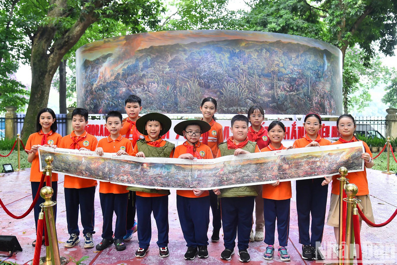 Les élèves de l'école primaire Trang An de Hanoï prennent des photos devant la fresque « Campagne de Diên Biên Phu » et les téléchargent sur les réseaux sociaux avec les hashtags #chienthangdienbienphu (victoire de Diên Biên Phu) et #dienbienphu. Photo: NDEL.