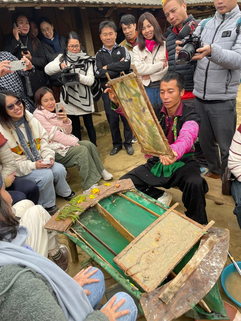 Trang A Cua présente aux visiteurs l'art des peintures traditionnelle sur papier. Photo : CVN