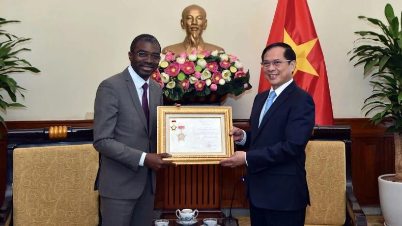 Le vice-Premier ministre et ministre vietnamien des Affaires étrangères, Bui Thanh Son (à droite), remet à Lazare Eloundou Assomo l'Insigne "Pour la cause de la diplomatie vietnamienne", pour honorer ses contributions exceptionnelles à la préservation et à la promotion des valeurs du patrimoine vietnamien, ainsi qu’au renforcement de la coopération entre le Vietnam et l'UNESCO. Photo: baoquocte.vn Le vice-Premier ministre et ministre vietnamien des Affaires étrangères, Bui Thanh Son (à droite), remet à Lazare Eloundou Assomo l'Insigne "Pour la cause de la diplomatie vietnamienne", pour honorer ses contributions exceptionnelles à la préservation et à la promotion des valeurs du patrimoine vietnamien, ainsi qu’au renforcement de la coopération entre le Vietnam et l'UNESCO. Photo: baoquocte.vn