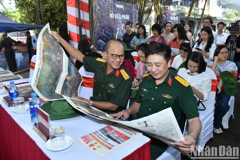 Les délégués observent le supplément spécial du quotidien Nhân Dân publié le 7 mai 2024 avec le tableau panoramique « Campagne de Diên Biên Phu ». Photo: NDEL.