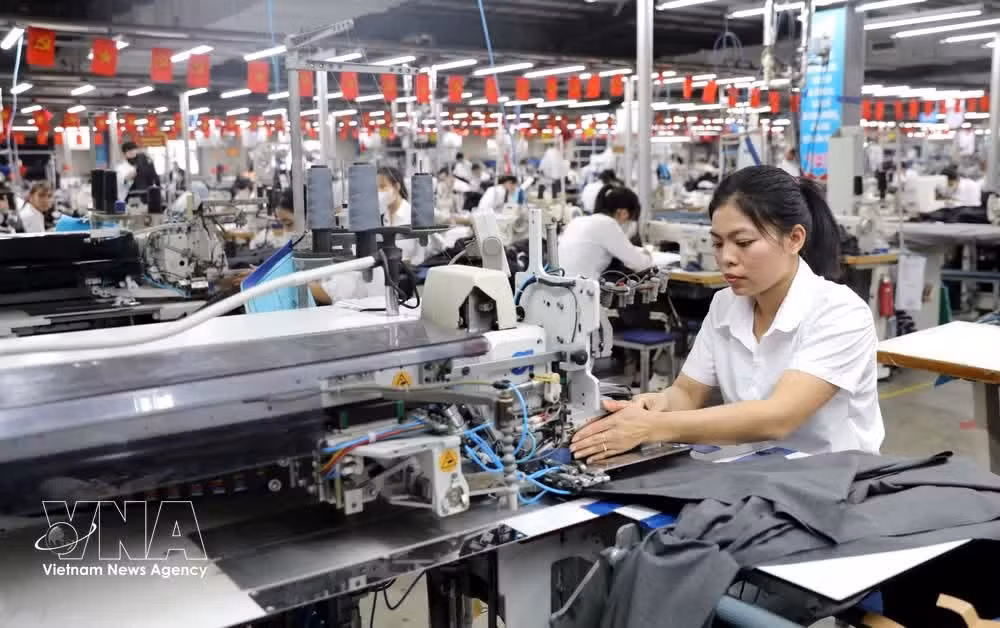 Une ouvrière utilise une machine à repasser à vapeur automatique à l'usine Hung Ha Veston. Photo : VNA.