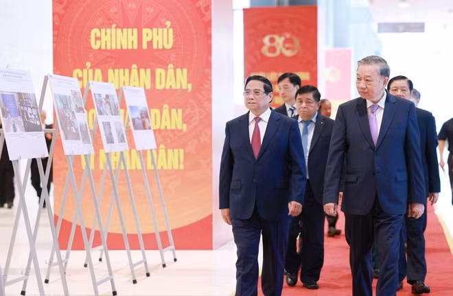 Le secrétaire général du PCV To Lam, le Premier ministre Pham Minh Chinh et des délégués visitent une exposition photographique sur les activités du gouvernement au fil des ans, produite par l'Agence vietnamienne d'information. Photo : VNA.