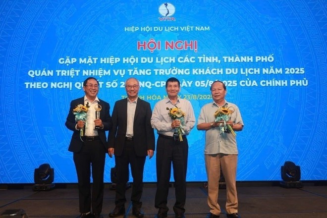 Le président de la VITA, Vu Thê Binh, remet des certificats de mérite et des insignes aux collectifs et aux individus pour leurs contributions à l'industrie du tourisme. hn.jpg