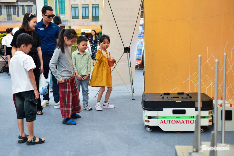 Les enfants s’amusent à observer et interagir avec les robots en démonstration dans la zone d’exposition. 7.jpg