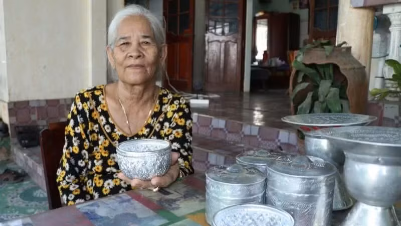 L’artisane Dang Thi My Tram (hameau de Bau Truc, commune de Ninh Phuoc, province de Khanh Hoa), aux côtés de ses créations artisanales traditionnelles de ciselure. Photo : nhandan.vn