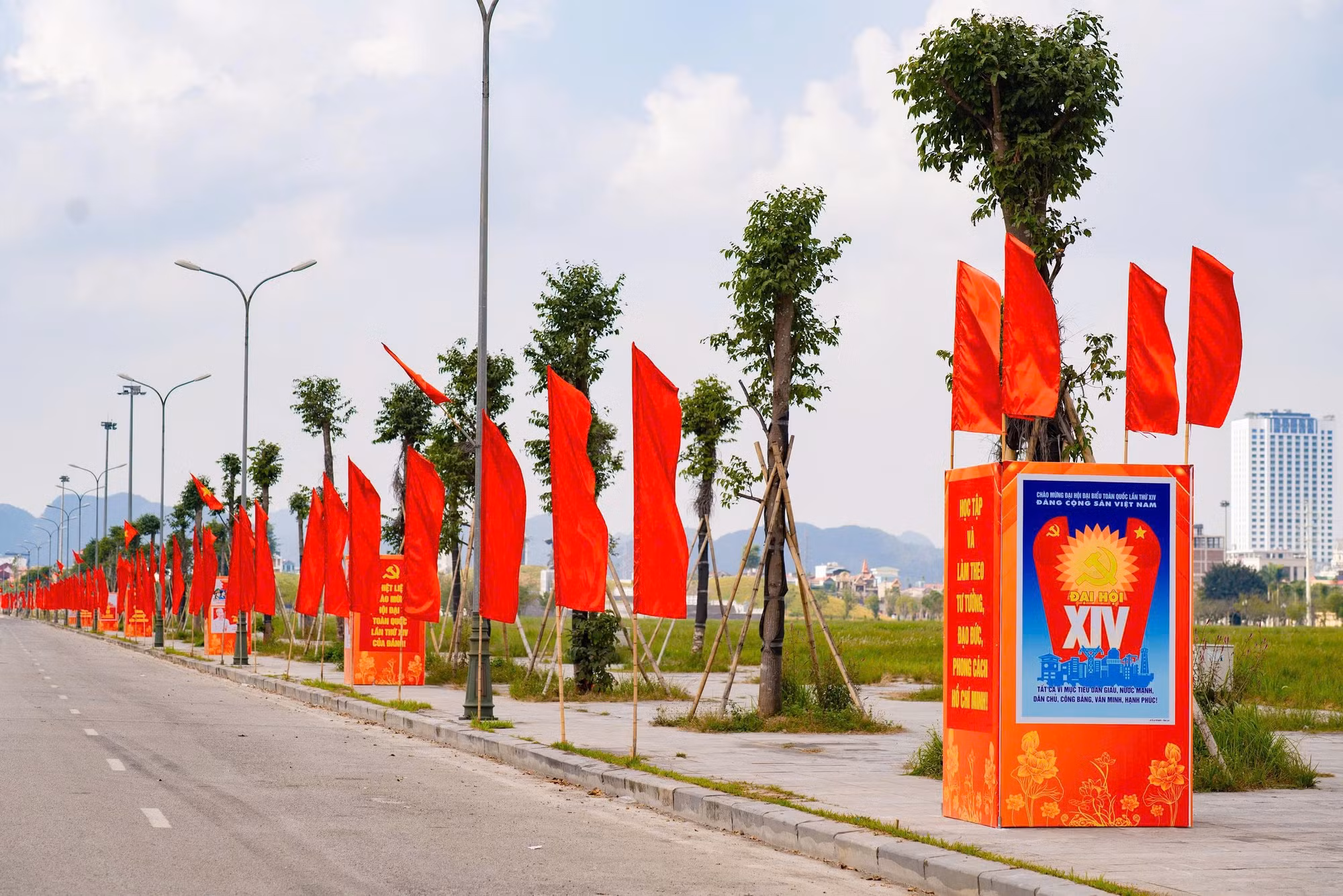 Un ensemble de panneaux, affiches et banderoles célébrant le XIVᵉ Congrès national du Parti est installé avec éclat le long de l’axe routier Dinh Dien. Photo : baoninhbinh.org.vn