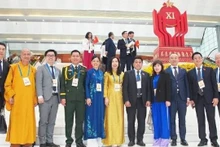 La vice-ministre des Affaires étrangères Lê Thị Thu Hằng pose pour une photo avec une délégation de Vietnamiens à l'étranger exemplaires venus assister au XIᵉ Congrès national d’émulation patriotique, le 27 décembre 2025. Photo : baoquocte.vn