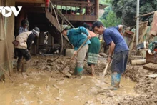 Les habitants de Suoi Lu s’entraident pour déblayer la boue et les débris. Photo : VOV.