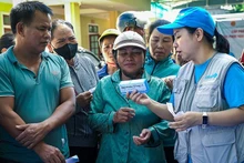 Un cadre de l’UNICEF aux côtés des habitants dans une zone touchée par les inondations et les glissements de terrain causés par les effets résiduels du typhon n°3. Photo : UNICEF.
