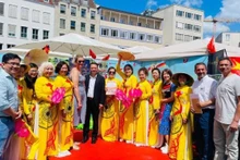 Des amis internationaux prennent une photo souvenir au stand du Vietnam. Photo : Revue Huong Viet.