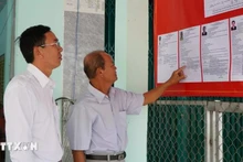 Des électeurs consultent les brèves biographies des candidats au Conseil populaire de la commune de Tan Hong, province de Dong Thap, mandat 2026-2031. Photo : VNA.