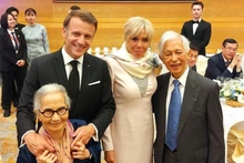 Le couple des professeurs Tran Thanh Van (à droite) et Le Kim Ngoc (à gauche) pose pour une photo avec le président de la République française et son épouse lors d’un dîner de réception à Hanoï, à l’occasion de la visite officielle du président en Vietnam. Photo : ICISE. 